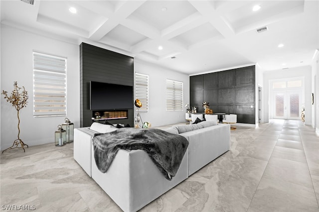 living room with beam ceiling, a healthy amount of sunlight, coffered ceiling, and a large fireplace