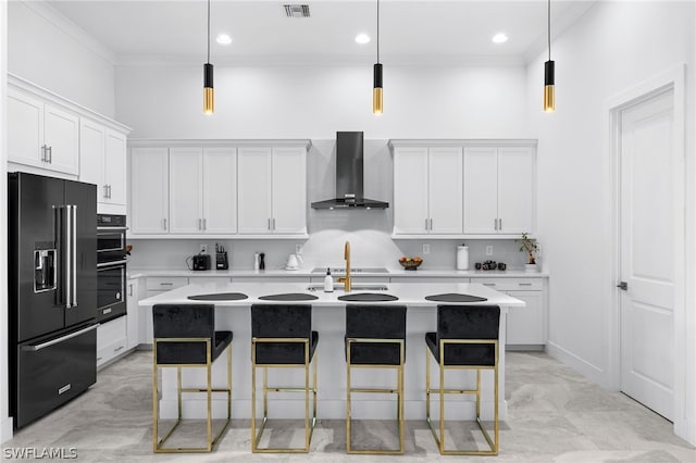 kitchen with an island with sink, wall chimney range hood, white cabinetry, and high end black fridge