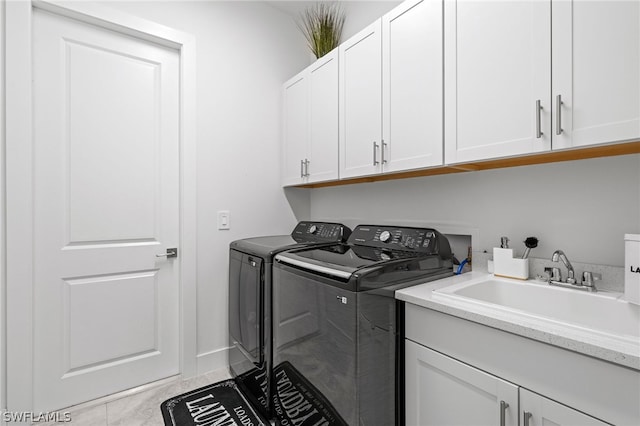 washroom with sink, light tile patterned floors, cabinets, and separate washer and dryer