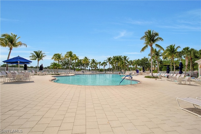 community pool with fence and a patio