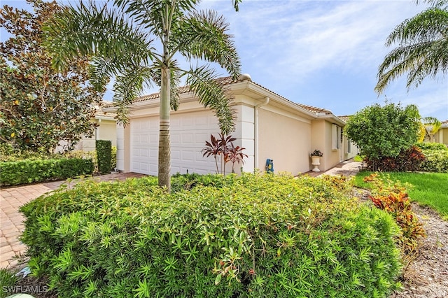 view of home's exterior with an attached garage and stucco siding