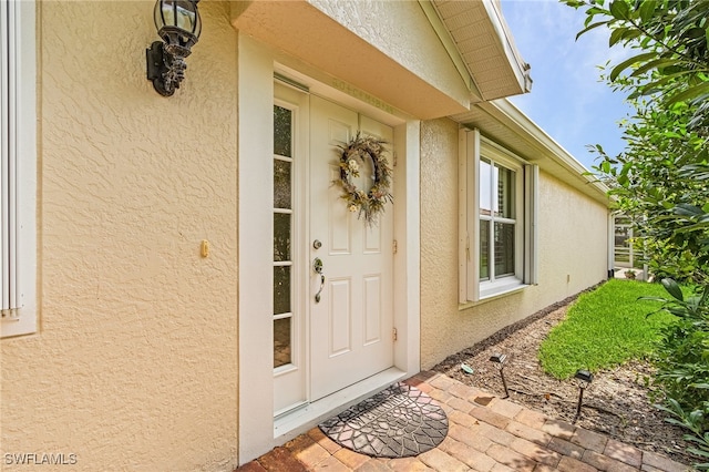 view of exterior entry featuring stucco siding