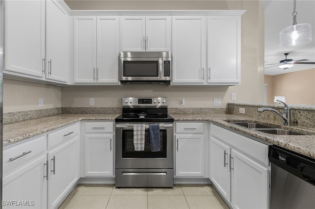 kitchen with stainless steel appliances, white cabinets, a sink, and light tile patterned floors