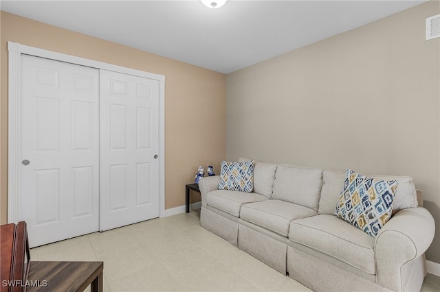 tiled living room featuring visible vents and baseboards