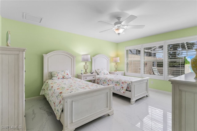 bedroom with a ceiling fan, marble finish floor, and baseboards