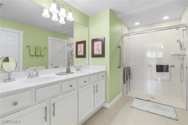 full bathroom featuring double vanity, tile patterned flooring, a sink, and a shower stall