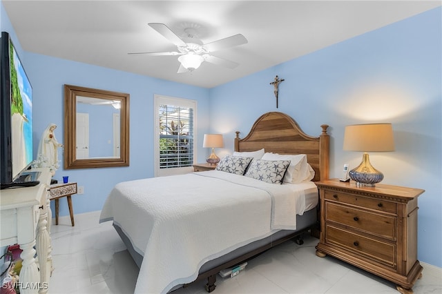 bedroom featuring a ceiling fan, marble finish floor, and baseboards