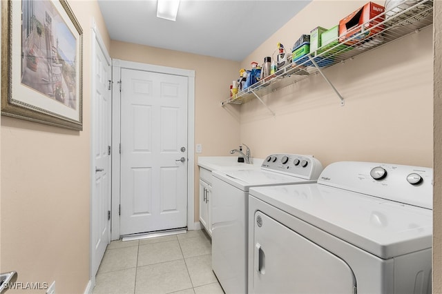 washroom featuring light tile patterned floors, cabinet space, a sink, and separate washer and dryer