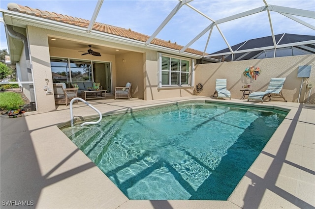 pool with ceiling fan, glass enclosure, an outdoor hangout area, and a patio area