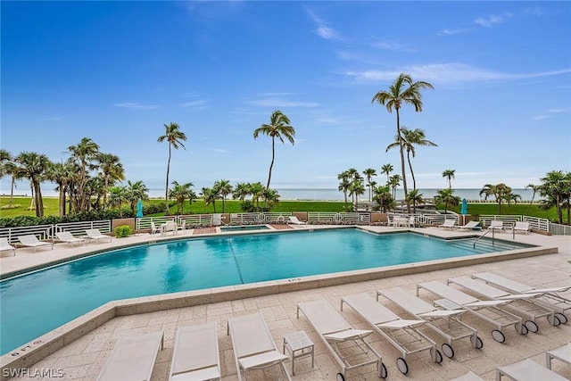 view of swimming pool featuring a water view and a patio