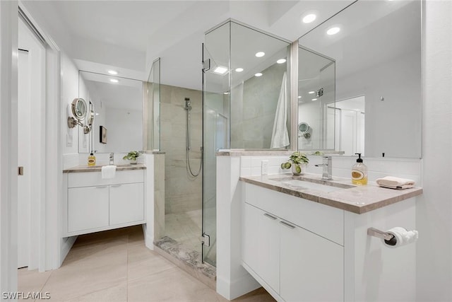 bathroom with tile patterned flooring, vanity, and walk in shower