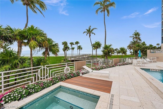 view of swimming pool featuring an in ground hot tub and a patio