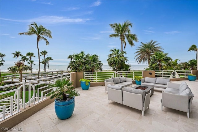 view of patio featuring a water view and an outdoor living space with a fire pit