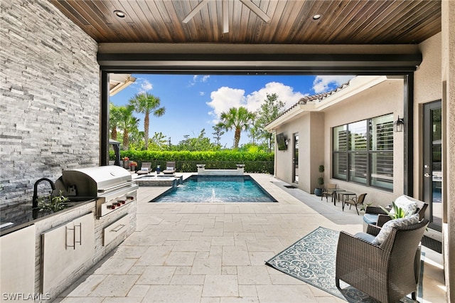 view of pool with area for grilling, a grill, a patio area, and pool water feature