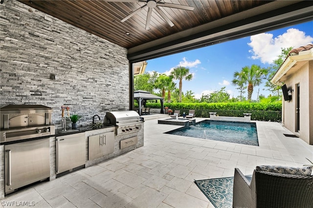 exterior space with ceiling fan, a gazebo, a patio area, area for grilling, and an outdoor kitchen