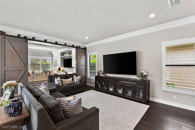 living room featuring crown molding, dark wood-type flooring, and a barn door