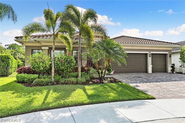 mediterranean / spanish-style house with a garage and a front lawn