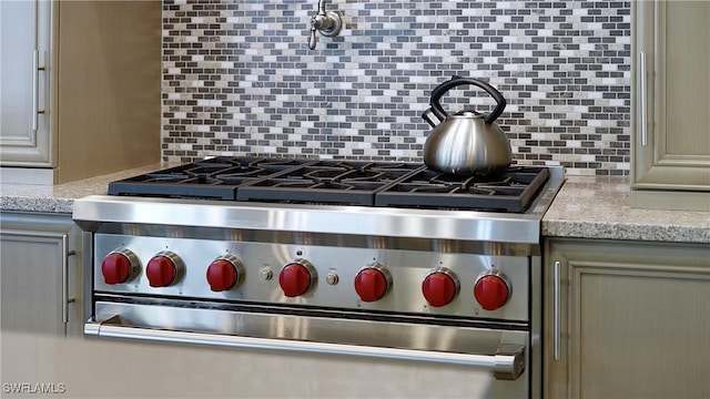 room details featuring light stone countertops, high end stove, and backsplash