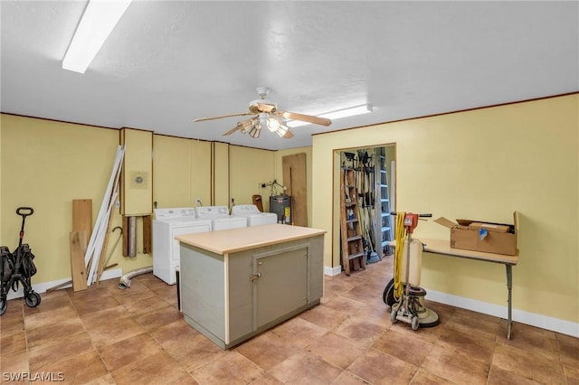 kitchen with electric water heater, ceiling fan, a kitchen island, and separate washer and dryer