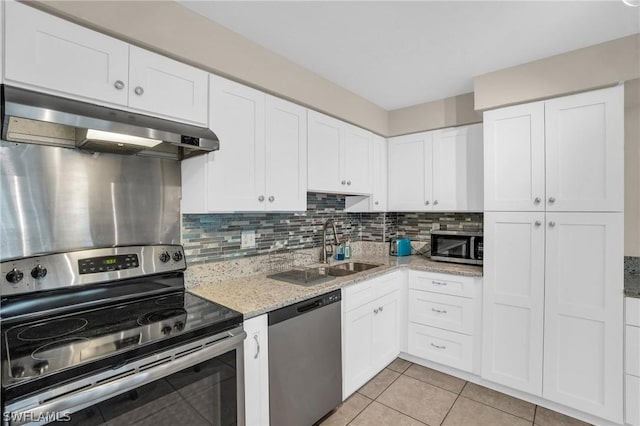 kitchen with decorative backsplash, white cabinets, light tile patterned floors, and appliances with stainless steel finishes