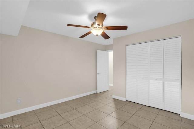 unfurnished bedroom with ceiling fan, light tile patterned floors, and a closet