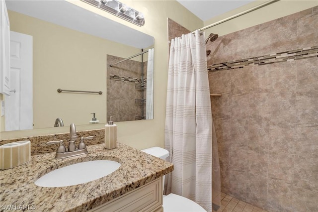 bathroom with tile patterned floors, vanity, toilet, and walk in shower