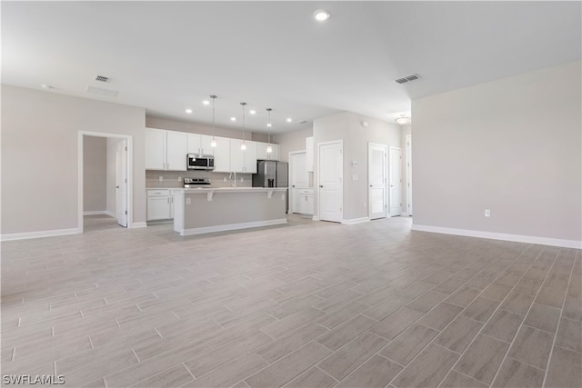 unfurnished living room with sink and light hardwood / wood-style flooring