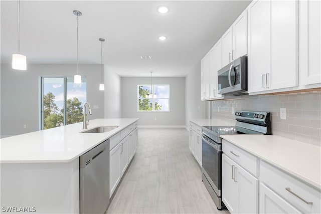 kitchen with stainless steel appliances, white cabinets, a wealth of natural light, and sink