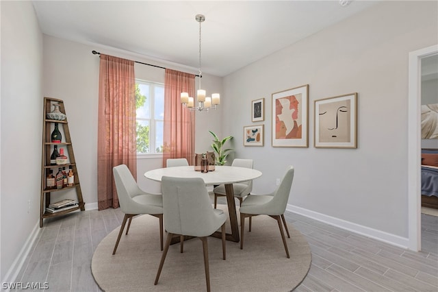 dining space with light hardwood / wood-style flooring and an inviting chandelier