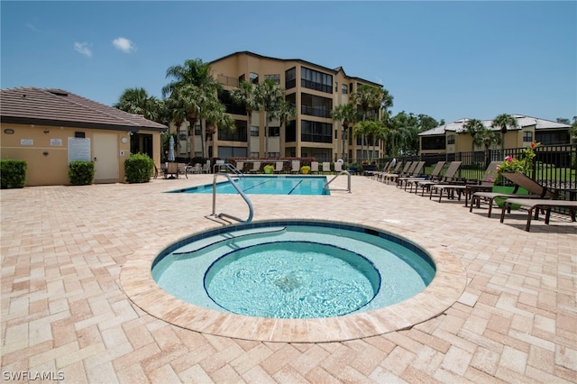 view of pool with a hot tub and a patio