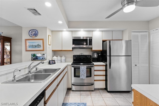 kitchen with white cabinets, ceiling fan, light tile floors, and stainless steel appliances