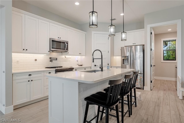 kitchen with stainless steel appliances, hanging light fixtures, sink, and backsplash