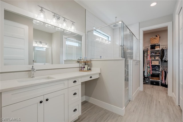 bathroom featuring walk in shower, wood-type flooring, and vanity