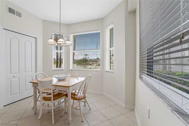 dining area featuring plenty of natural light, a chandelier, and light tile floors