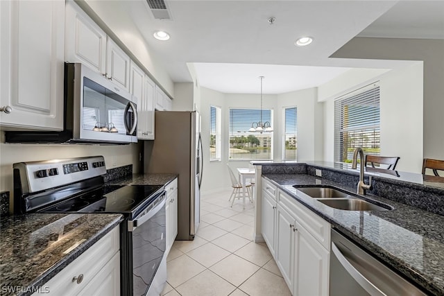 kitchen with hanging light fixtures, stainless steel appliances, dark stone counters, white cabinets, and sink