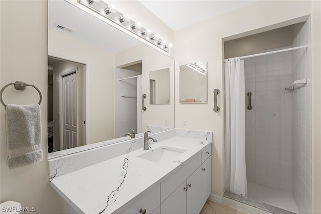 bathroom featuring vanity with extensive cabinet space, walk in shower, and tile flooring