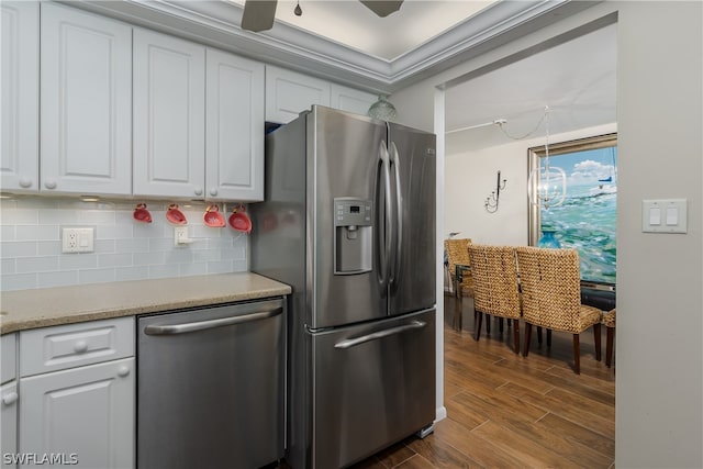 kitchen featuring ceiling fan, tasteful backsplash, dark wood-type flooring, white cabinets, and appliances with stainless steel finishes