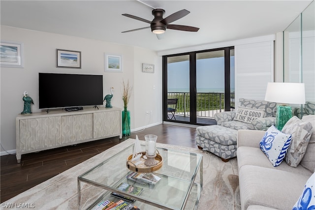 living room with ceiling fan, a water view, and dark hardwood / wood-style flooring