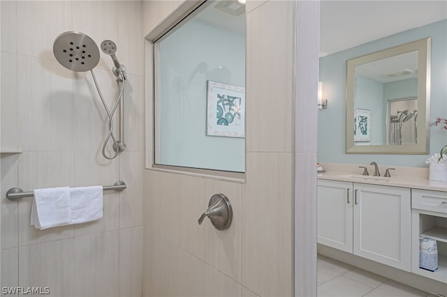 bathroom featuring a tile shower, tile floors, and vanity