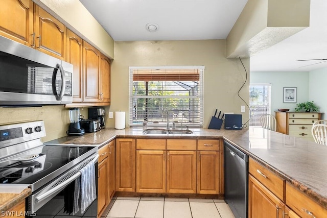 kitchen with stainless steel appliances, sink, and light tile floors