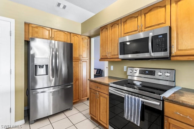 kitchen featuring light tile floors and stainless steel appliances