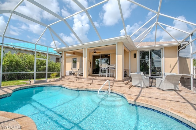 view of swimming pool with a patio, a lanai, and ceiling fan