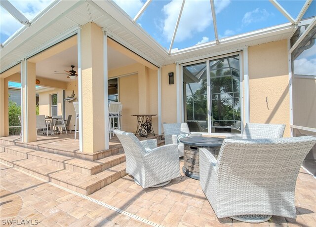 view of patio with glass enclosure and ceiling fan