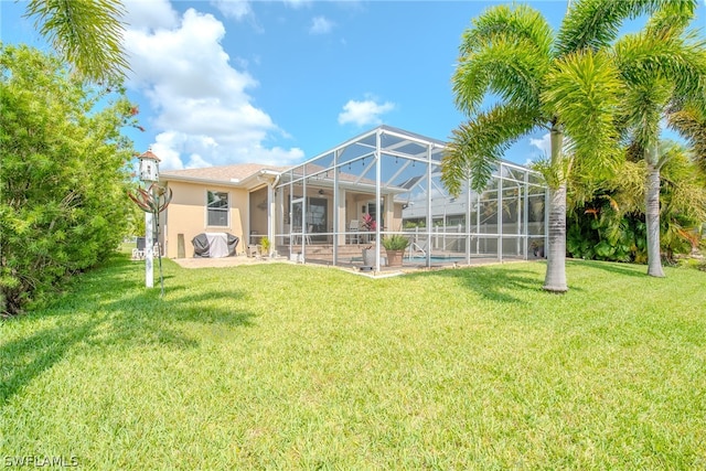 rear view of property featuring a patio, glass enclosure, and a lawn