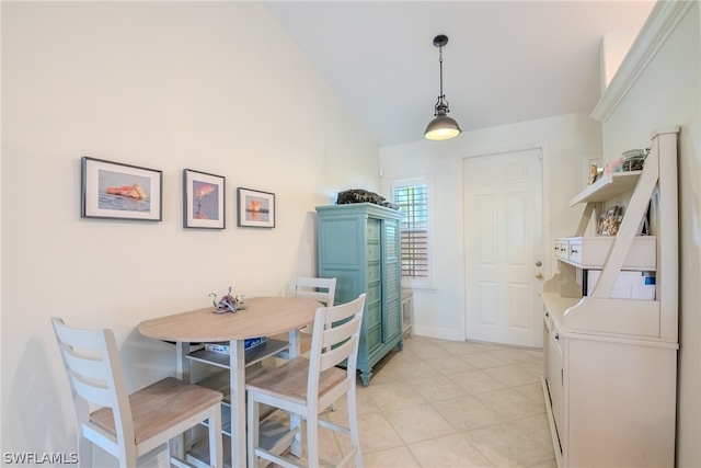 dining room featuring vaulted ceiling and light tile flooring