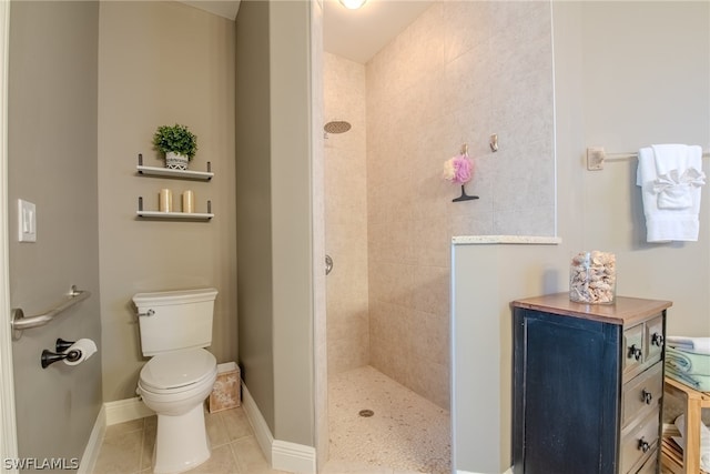 bathroom featuring a tile shower, tile flooring, and toilet