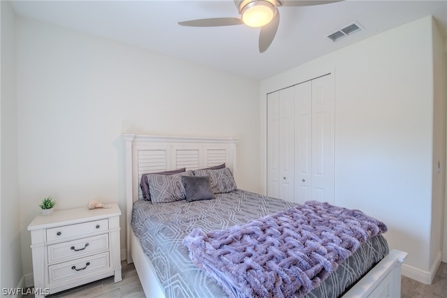 bedroom with a closet, ceiling fan, and light hardwood / wood-style flooring