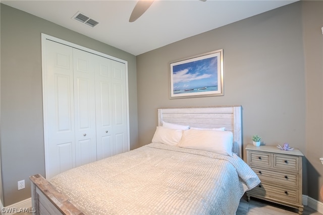 bedroom with hardwood / wood-style floors, a closet, and ceiling fan