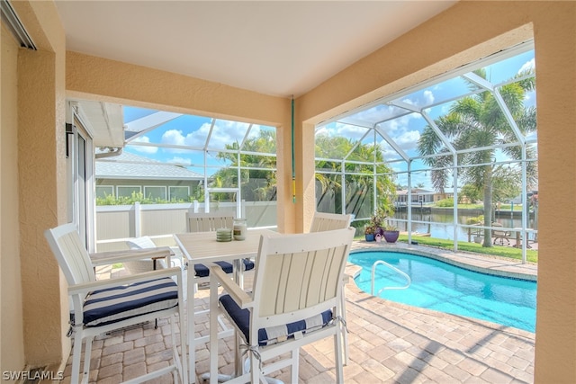 view of pool featuring a lanai, a water view, and a patio