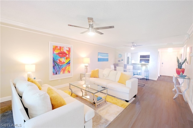 living room with crown molding, a textured ceiling, ceiling fan, and hardwood / wood-style floors